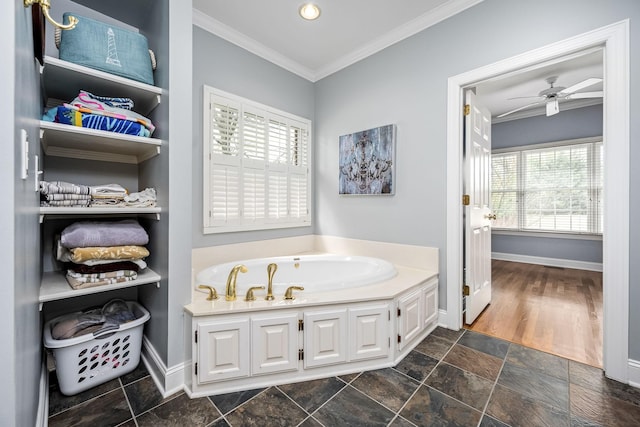 bathroom featuring stone finish flooring, a bath, baseboards, and crown molding