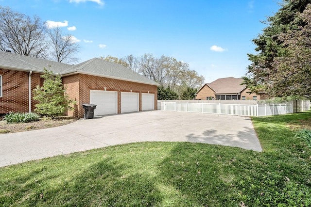 view of side of property with concrete driveway, a yard, brick siding, and fence