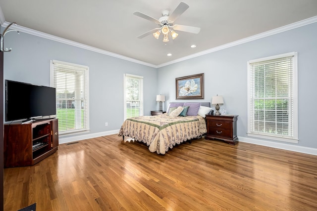 bedroom with visible vents, baseboards, crown molding, recessed lighting, and wood finished floors