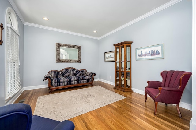 living area featuring crown molding, baseboards, recessed lighting, and wood finished floors