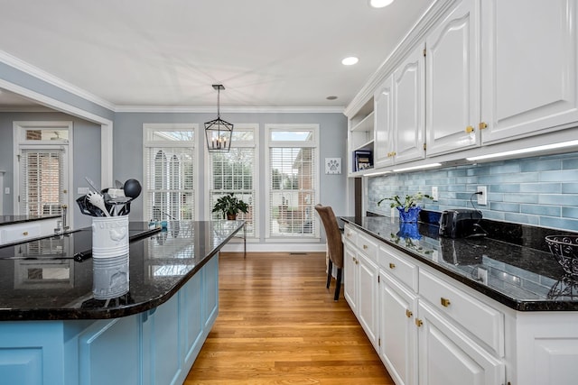 kitchen featuring tasteful backsplash, open shelves, ornamental molding, light wood-type flooring, and white cabinetry
