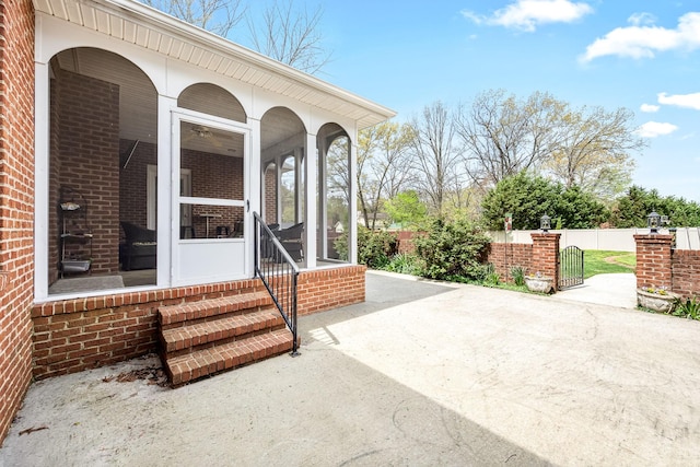 view of patio / terrace with fence and a sunroom