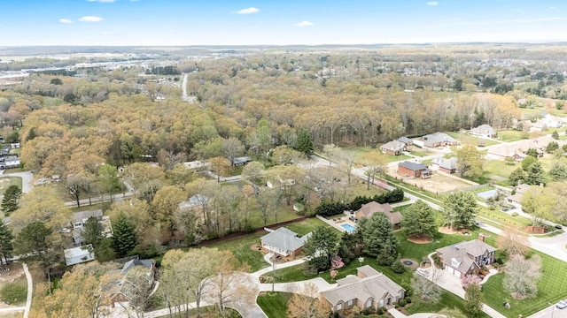 drone / aerial view featuring a residential view and a view of trees