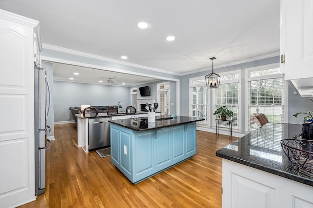 kitchen featuring a kitchen island, white cabinets, light wood-style floors, stainless steel appliances, and blue cabinets