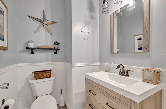 half bathroom with vanity and toilet