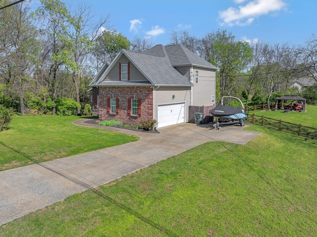 view of side of property featuring a yard, a garage, fence, brick siding, and driveway