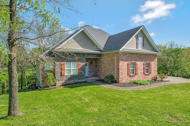 view of front of house with roof with shingles, a front lawn, and brick siding
