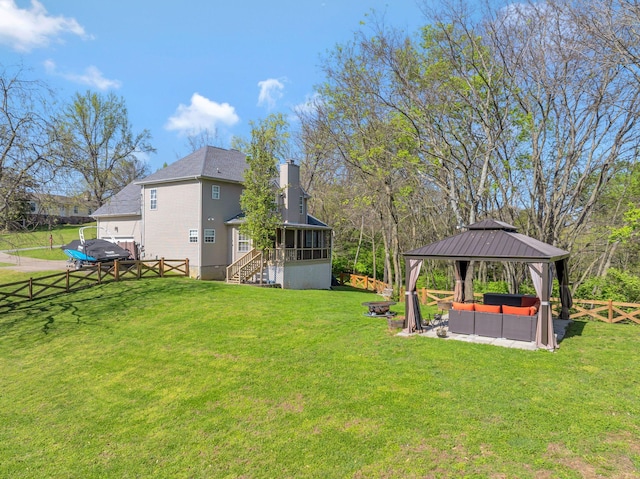 view of yard featuring a sunroom, a gazebo, an outdoor hangout area, and a fenced backyard