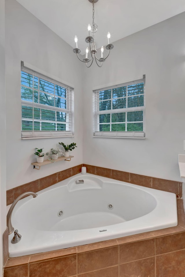 bathroom with a chandelier and a tub with jets