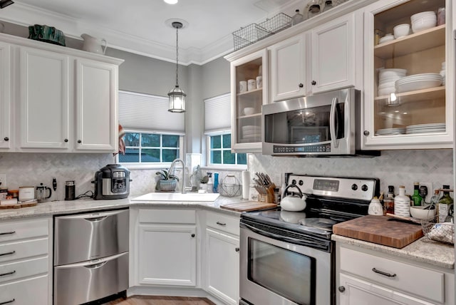 kitchen with a sink, white cabinets, decorative backsplash, and stainless steel appliances