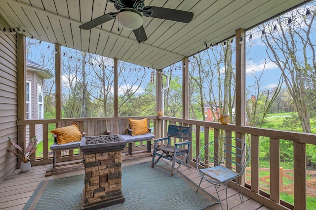 wooden deck featuring an outdoor fire pit and a ceiling fan