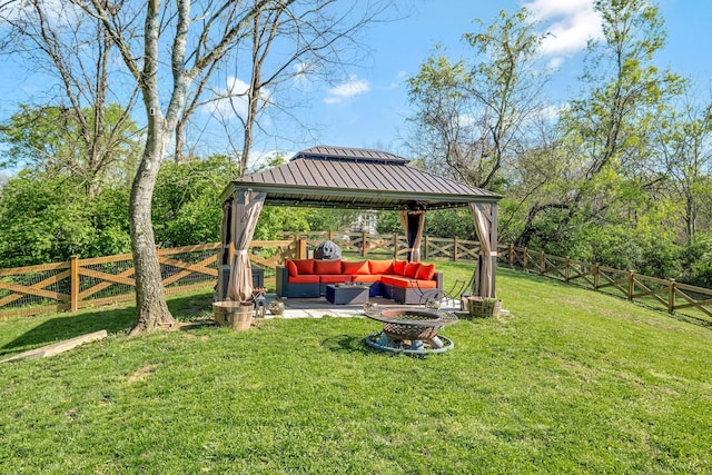 view of yard with an outdoor living space with a fire pit, a fenced backyard, and a gazebo