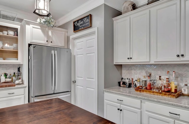 bar featuring tasteful backsplash, a dry bar, freestanding refrigerator, and ornamental molding