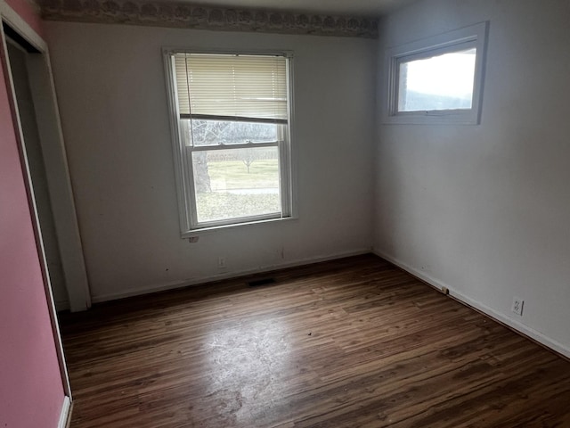 empty room featuring baseboards and wood finished floors
