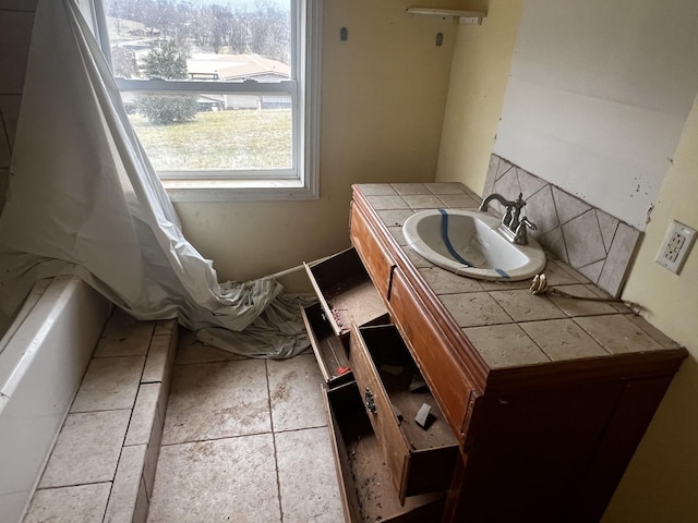 bathroom featuring tile patterned flooring, decorative backsplash, and vanity