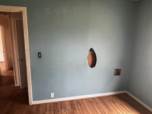 empty room featuring baseboards and wood finished floors