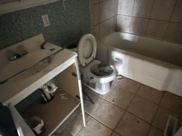 bathroom featuring visible vents, toilet, tile patterned flooring, and tile walls