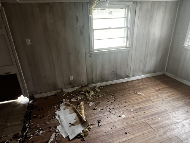 unfurnished room featuring wooden walls and hardwood / wood-style flooring