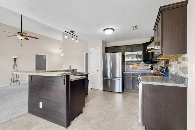 1995 General Neyland Dr, Clarksville, TN 37042 - kitchen with tasteful backsplash, dark brown cabinetry, a ceiling fan, a kitchen bar, and appliances with stainless steel finishes