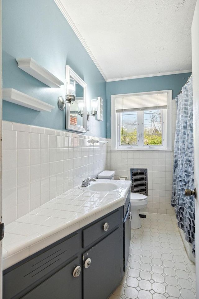 bathroom featuring vanity, ornamental molding, toilet, tile walls, and tile patterned floors