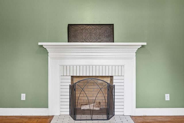interior details featuring baseboards and a brick fireplace