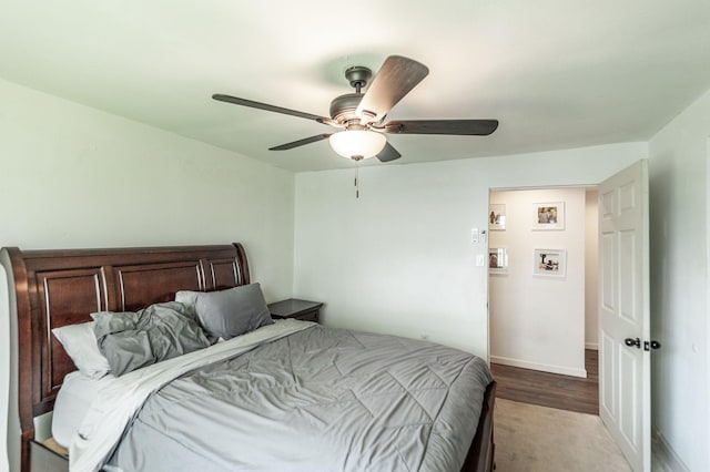 bedroom with light wood-style flooring, baseboards, and a ceiling fan