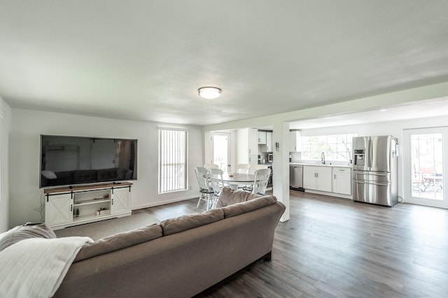 living room featuring dark wood-style flooring and a wealth of natural light