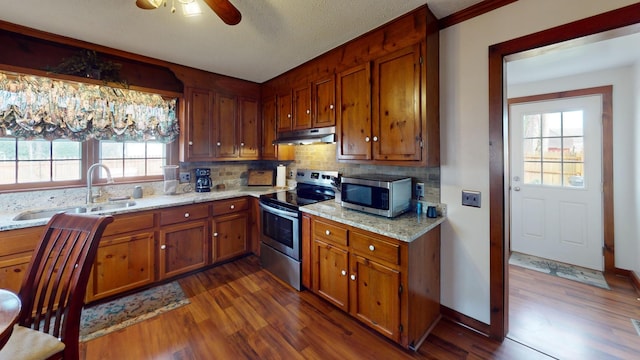 2519 Old Greenbrier Pike, Greenbrier, TN 37073 - kitchen featuring a sink, brown cabinetry, under cabinet range hood, and stainless steel appliances