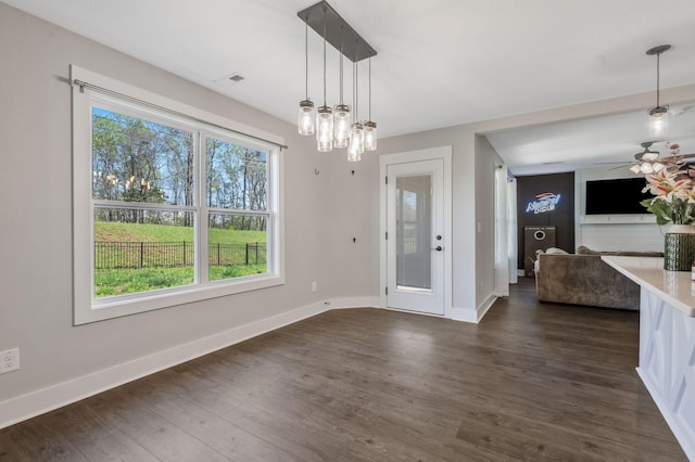unfurnished dining area with visible vents, baseboards, ceiling fan, and dark wood-style floors