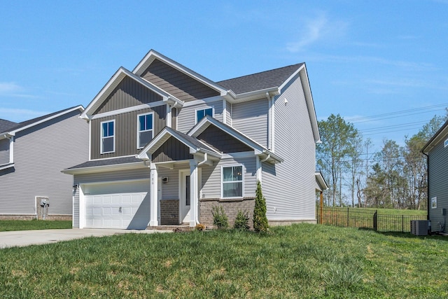 craftsman house with central AC unit, driveway, fence, and a front lawn