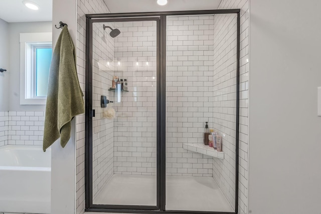 bathroom featuring a bath and a stall shower