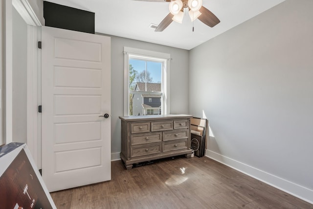 bedroom featuring dark wood-type flooring, visible vents, baseboards, and ceiling fan