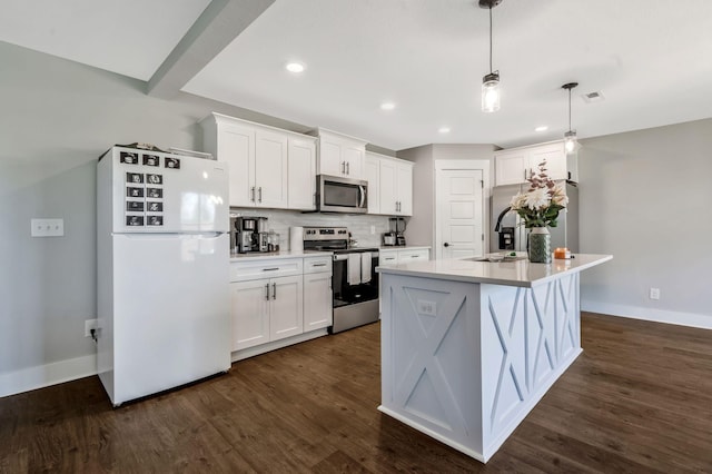 kitchen with a sink, baseboards, appliances with stainless steel finishes, and white cabinetry