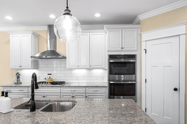 15 Westlawn Ct, Nashville, TN 37209 - kitchen featuring appliances with stainless steel finishes, decorative light fixtures, wall chimney exhaust hood, decorative backsplash, and a sink