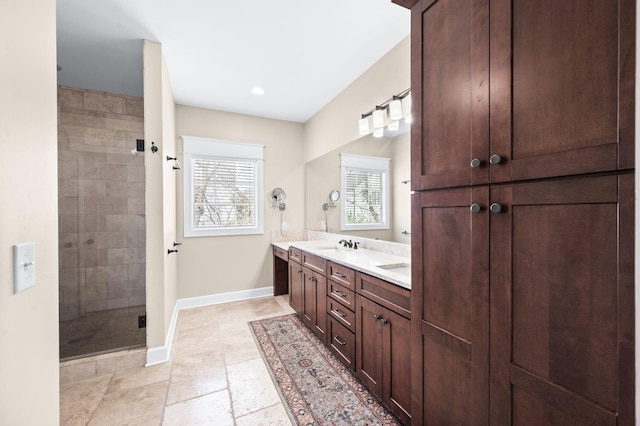 15 Westlawn Ct, Nashville, TN 37209 - full bathroom featuring baseboards, double vanity, stone tile flooring, a shower stall, and a sink