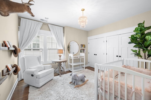 15 Westlawn Ct, Nashville, TN 37209 - bedroom with visible vents, baseboards, an inviting chandelier, and wood finished floors