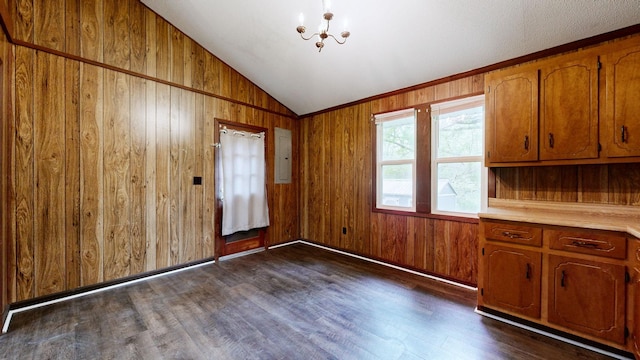 interior space featuring wooden walls, dark wood-style flooring, an inviting chandelier, and lofted ceiling