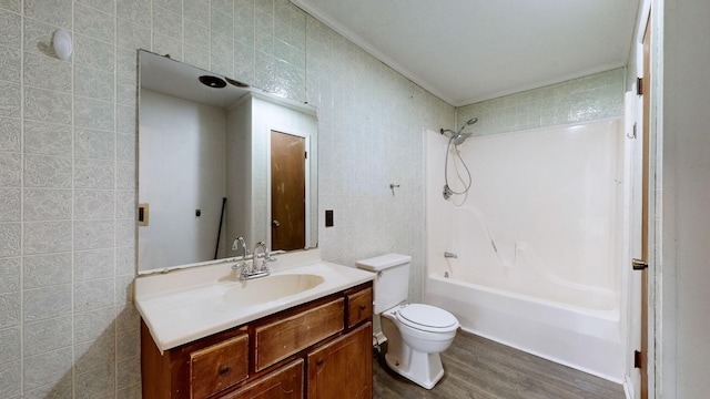 full bathroom featuring vanity, toilet, bathtub / shower combination, tile walls, and wood finished floors