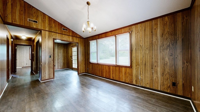 unfurnished room with vaulted ceiling, an inviting chandelier, dark wood-style floors, wood walls, and visible vents