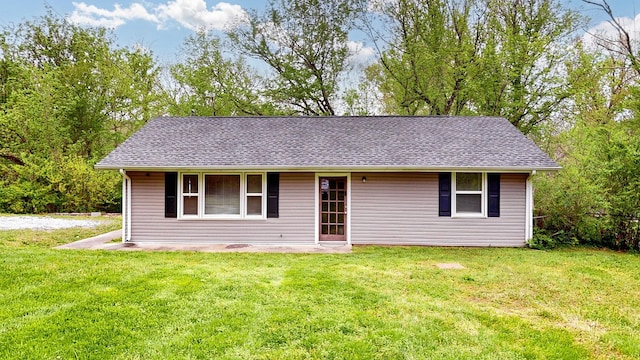 ranch-style home featuring a front lawn and a shingled roof