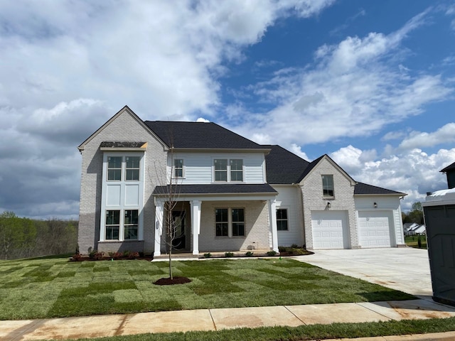 view of front of home with brick siding, a front lawn, an attached garage, and driveway