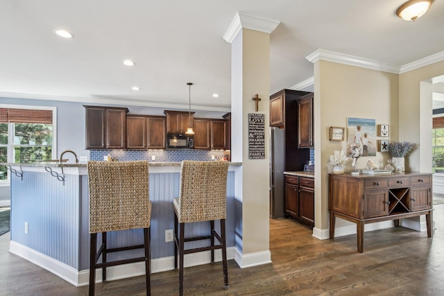 1702 Stoney Hill Ln, Spring Hill, TN 37174 - kitchen featuring a kitchen breakfast bar, backsplash, ornamental molding, black microwave, and dark wood-style flooring