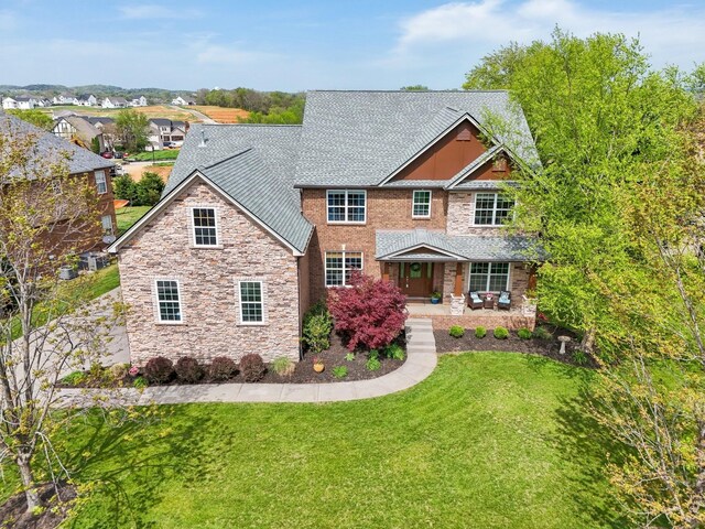 1702 Stoney Hill Ln, Spring Hill, TN 37174 - view of front of property with a front lawn, roof with shingles, a porch, and stone siding