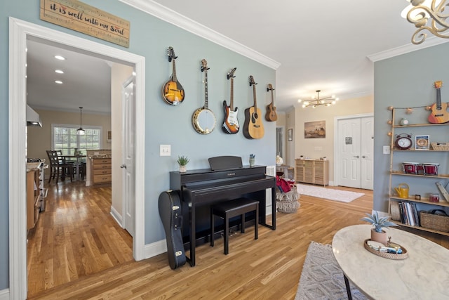 living area featuring crown molding, baseboards, light wood-type flooring, and a notable chandelier