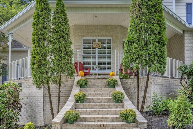 property entrance featuring brick siding and a porch