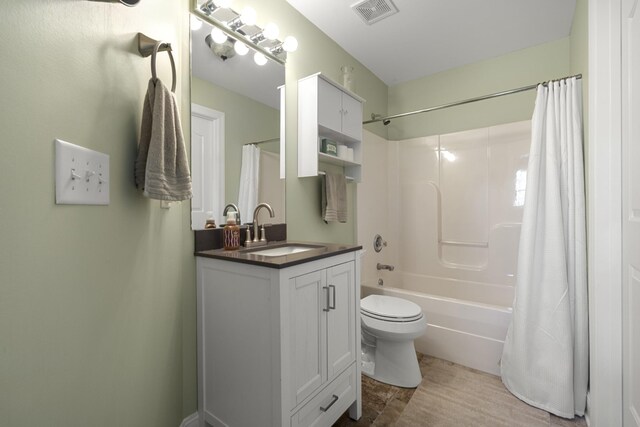 bathroom featuring toilet, visible vents, vanity, and shower / tub combo with curtain