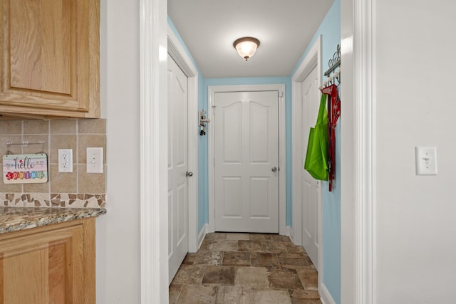 doorway with baseboards and stone finish flooring
