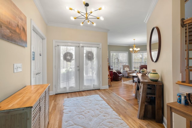 foyer entrance featuring light wood-style floors, a notable chandelier, stairway, and crown molding