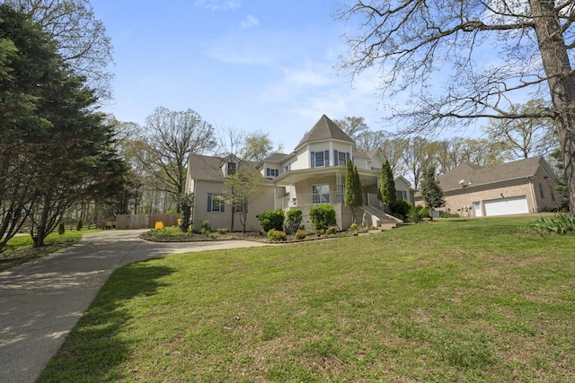 victorian house featuring a front yard and driveway