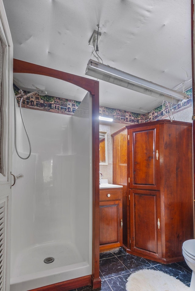 bathroom with a shower stall, vanity, marble finish floor, and toilet